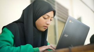 A younger student studying possibly remotely using a chromebook laptop