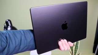 MacBook Pro 14 M3 Max (2023) being held in a hand