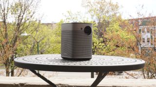 outdoor projector on table, trees in background