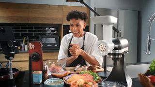 A person livestreams a cookery lesson using an iPhone and the Canon Live Switcher Mobile app.