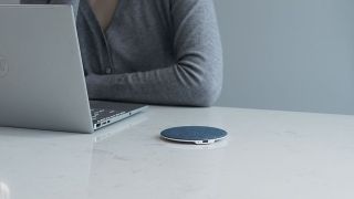 SluTune Q1 Bluetooth speaker on a desk next to a laptop