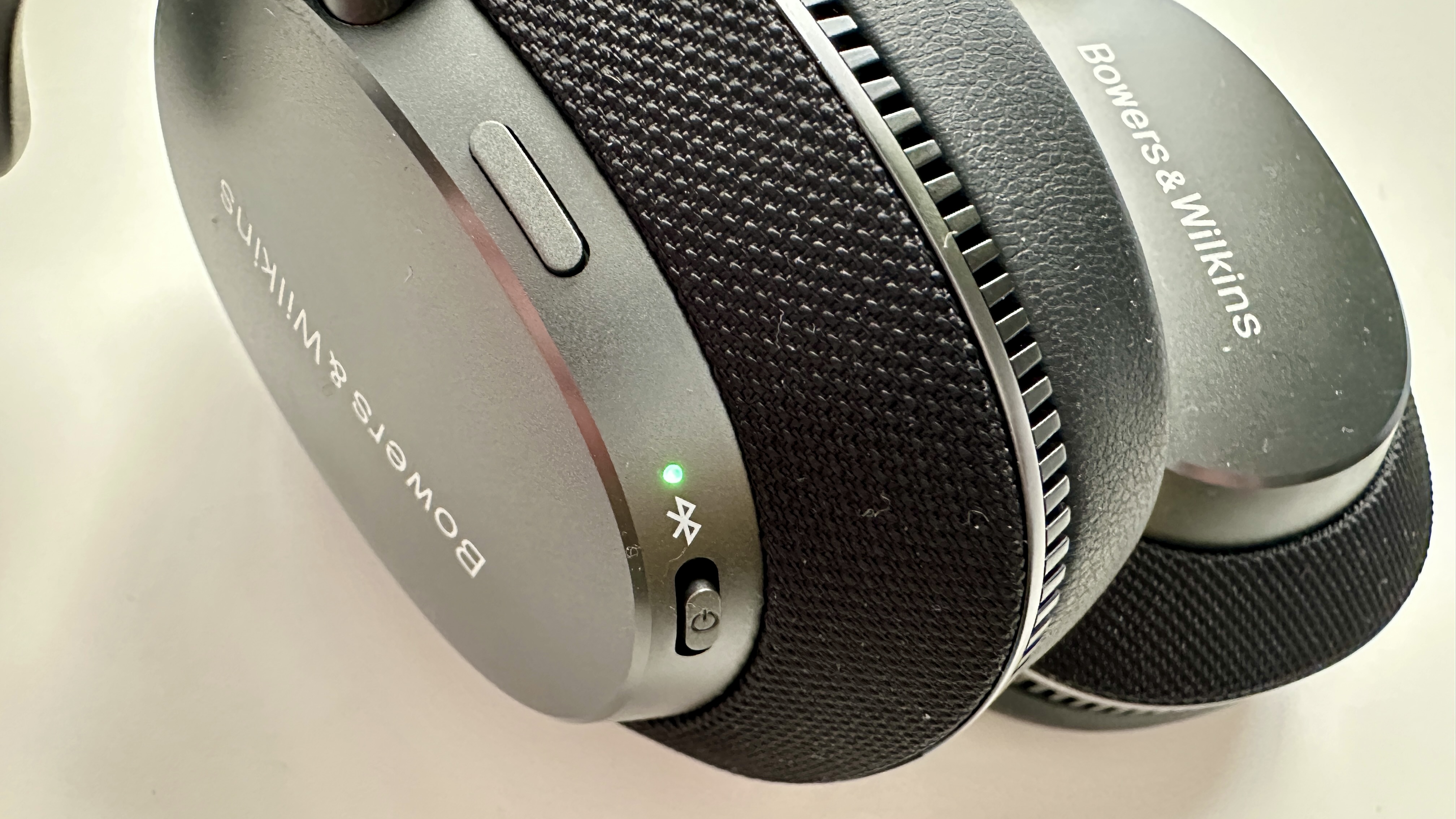 Integrated side buttons on Bowers & Wilkins Px7 S3 over-ear headphones, on a white surface