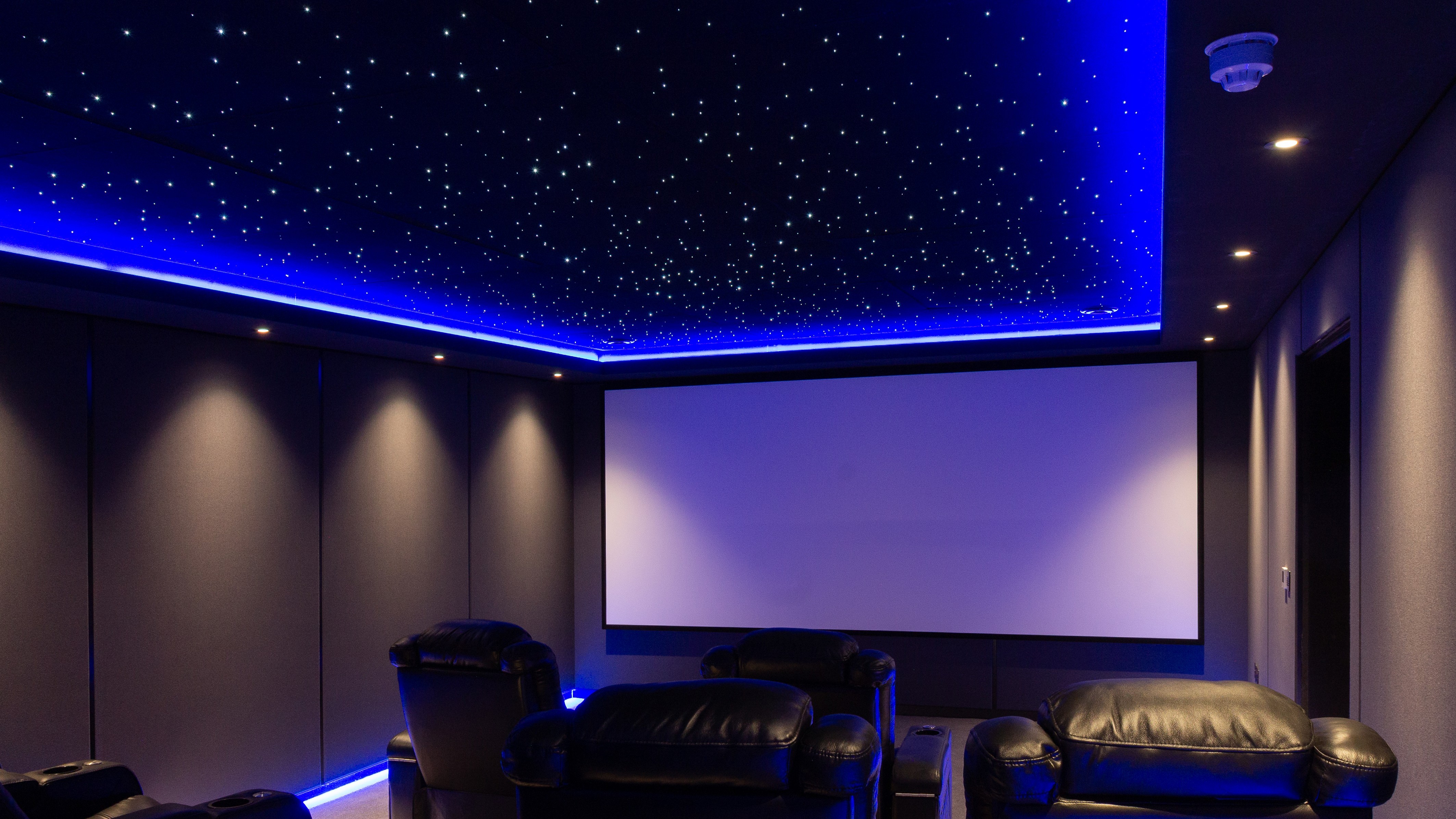 Warwickshire home theater showing seating, projection screen and starlight ceiling