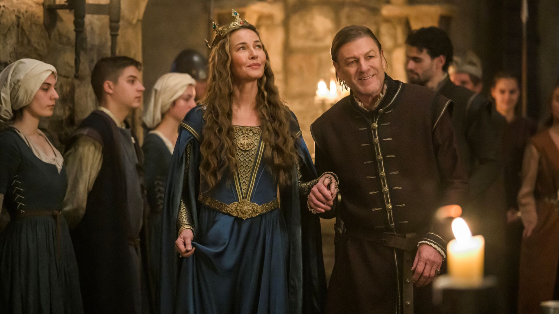Sean Bean holds Connie Nielsen&#039;s hand while leading her around a banquet hall filled with staff