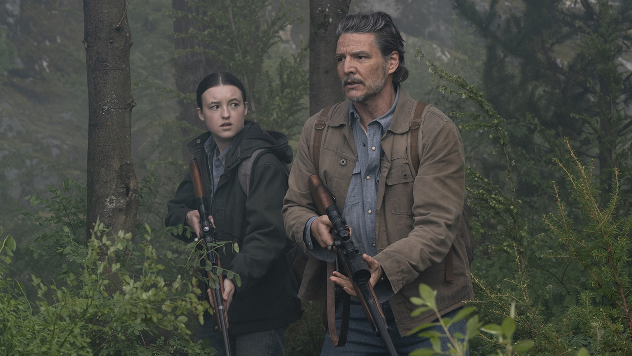 Ellie and Joel holding rifles as they walk through a forest in The Last of Us season 2 episode 6