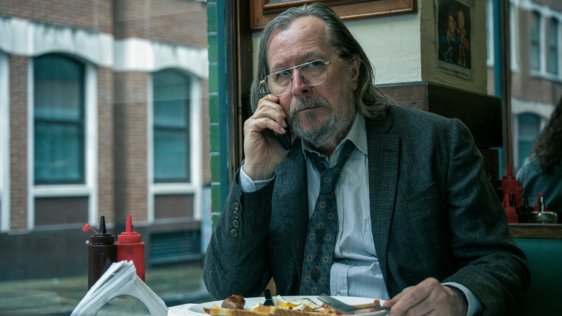 Jackson Lamb taking a phone call as he eats a meal in Slow Horses season 5