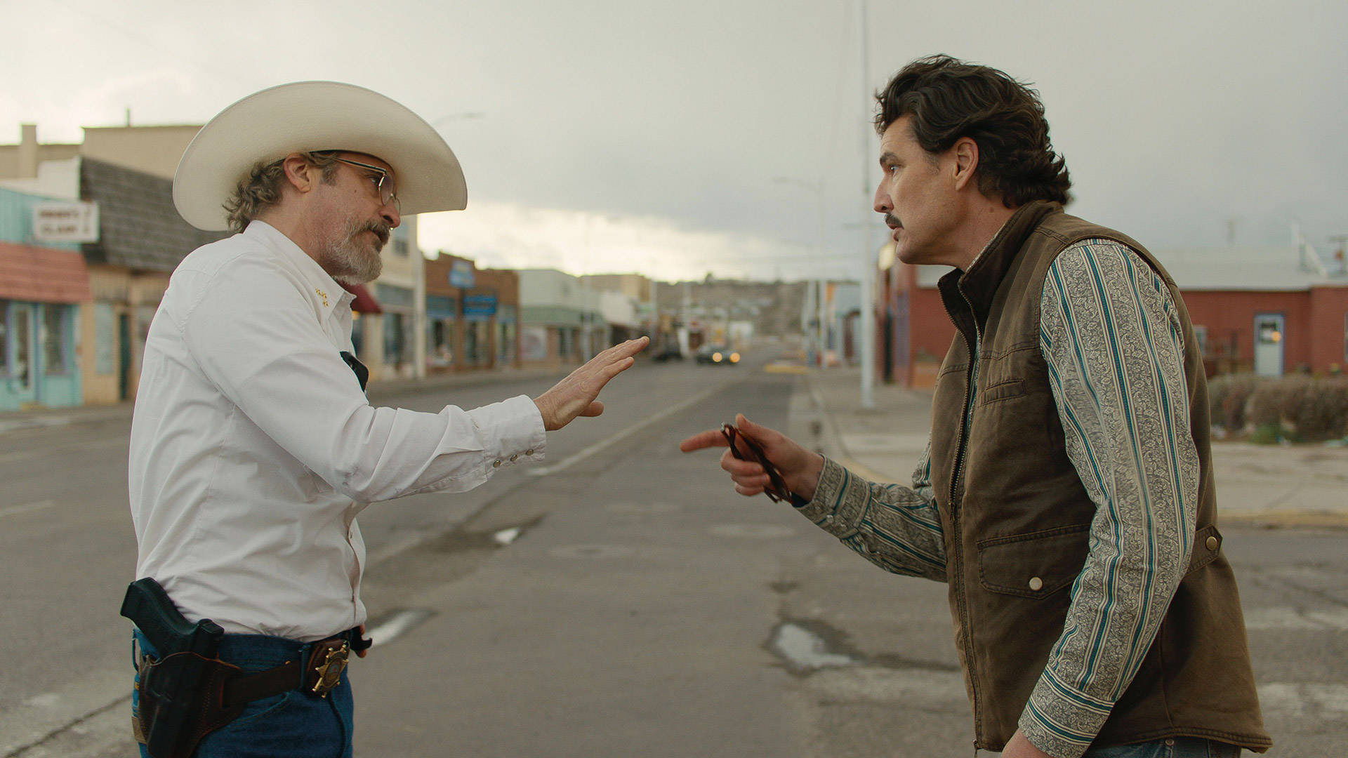 Joaquin Phoenix and Pedro Pascal face off against each other in the street in the movie Eddington.