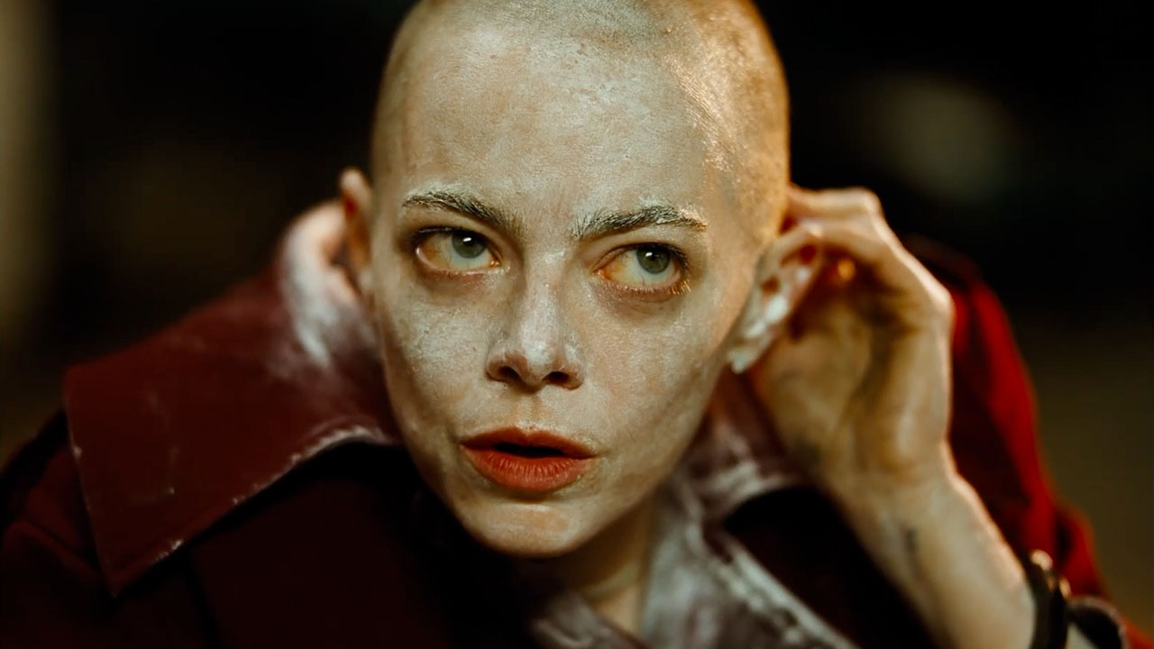 Emma Stone's Michelle wearing white makeup with her head shaved in Bugonia