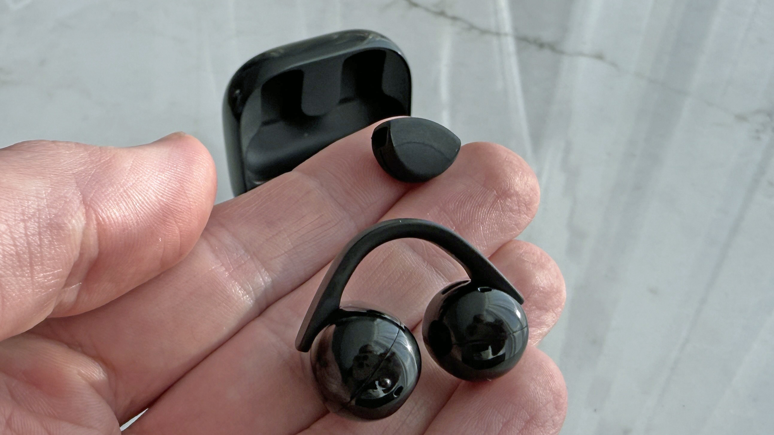 Sony LinkBuds Clip in man's hand, showing the clip and air cushion separately