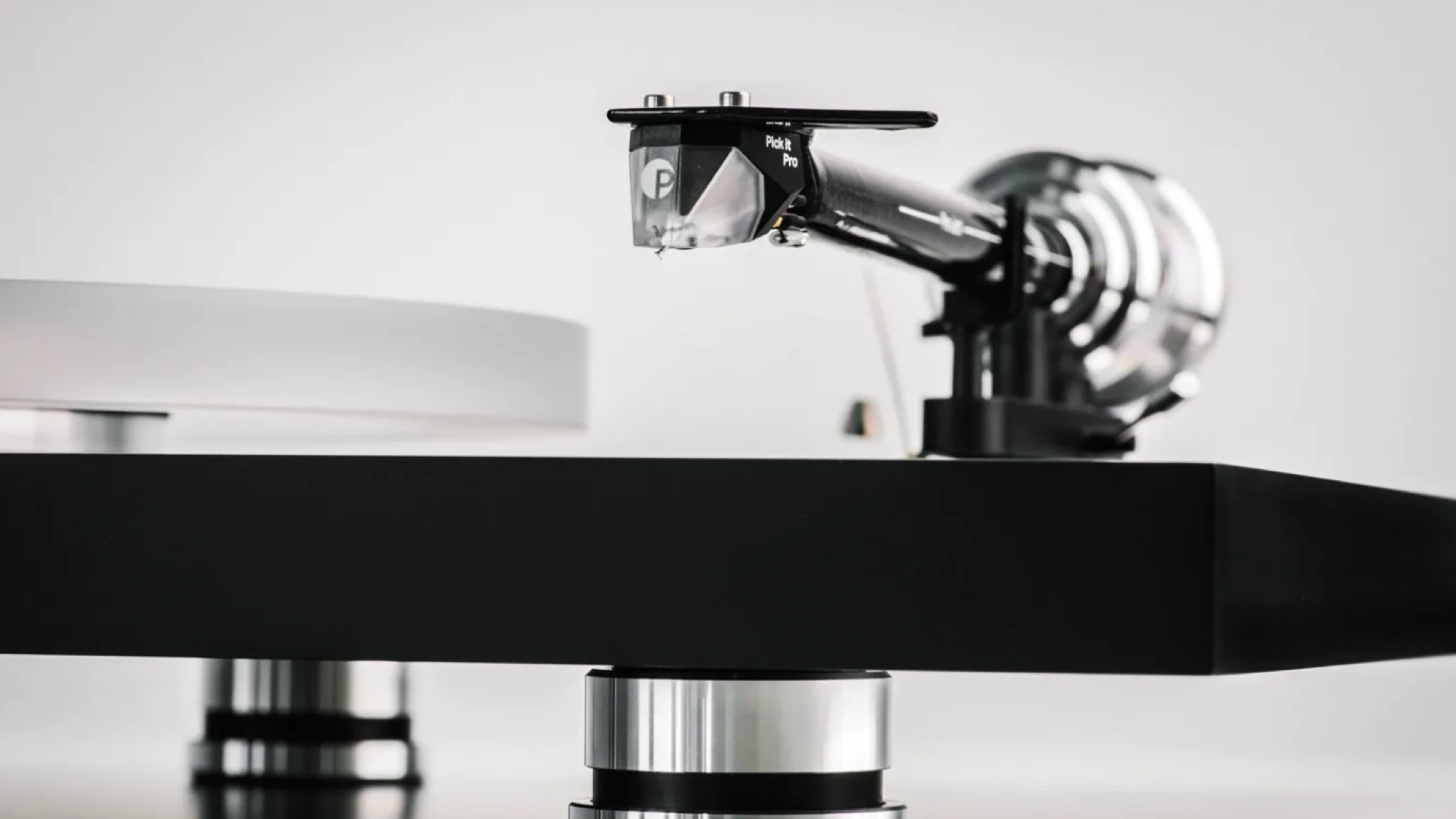 Pro-Ject Debut Reference 10 promotional image showing a close-up of the tonearm and cartridge