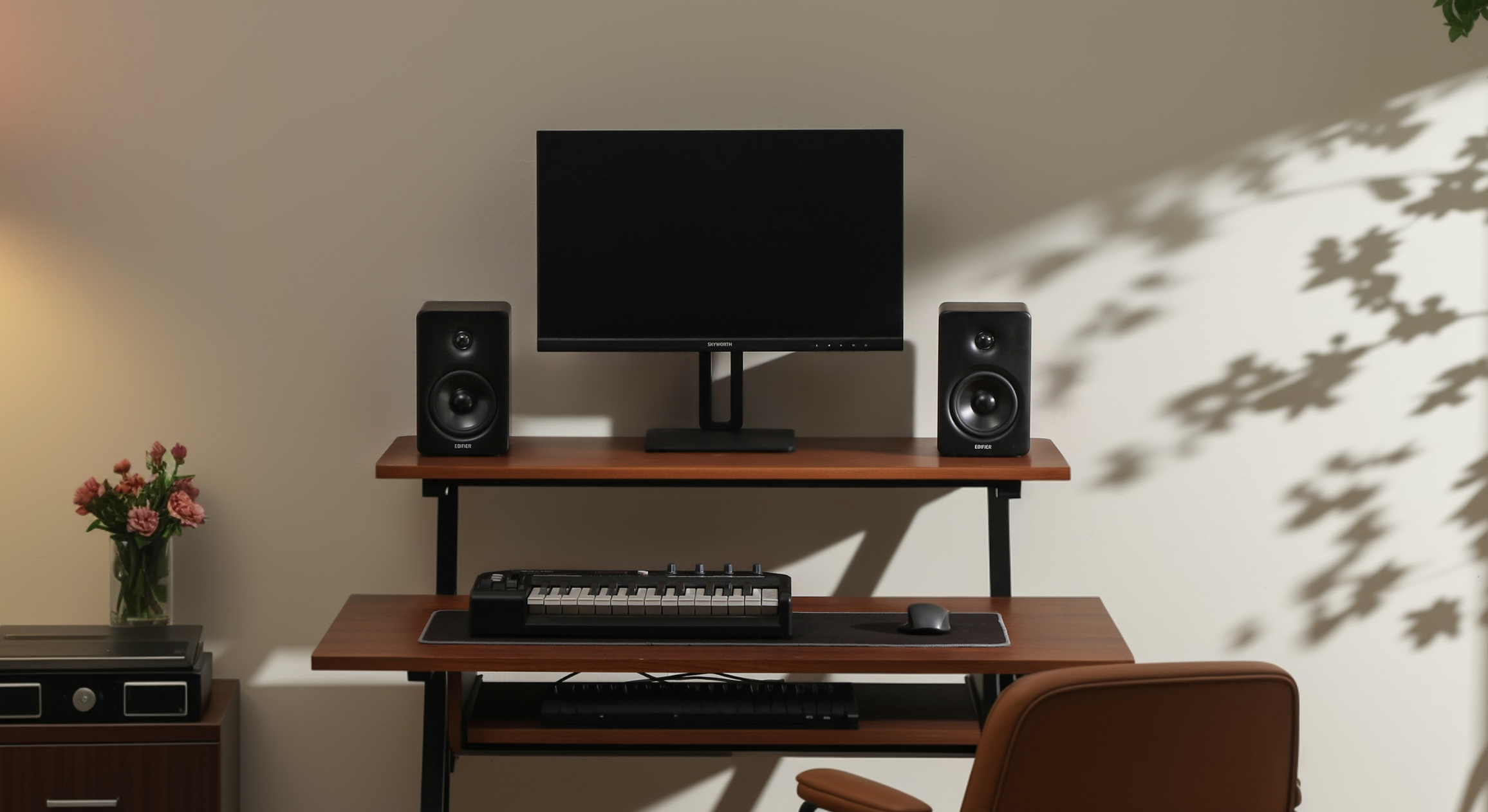 Edifier M90 speaker in black, either side of a desktop monitor, in an office with a keyboard and office chair