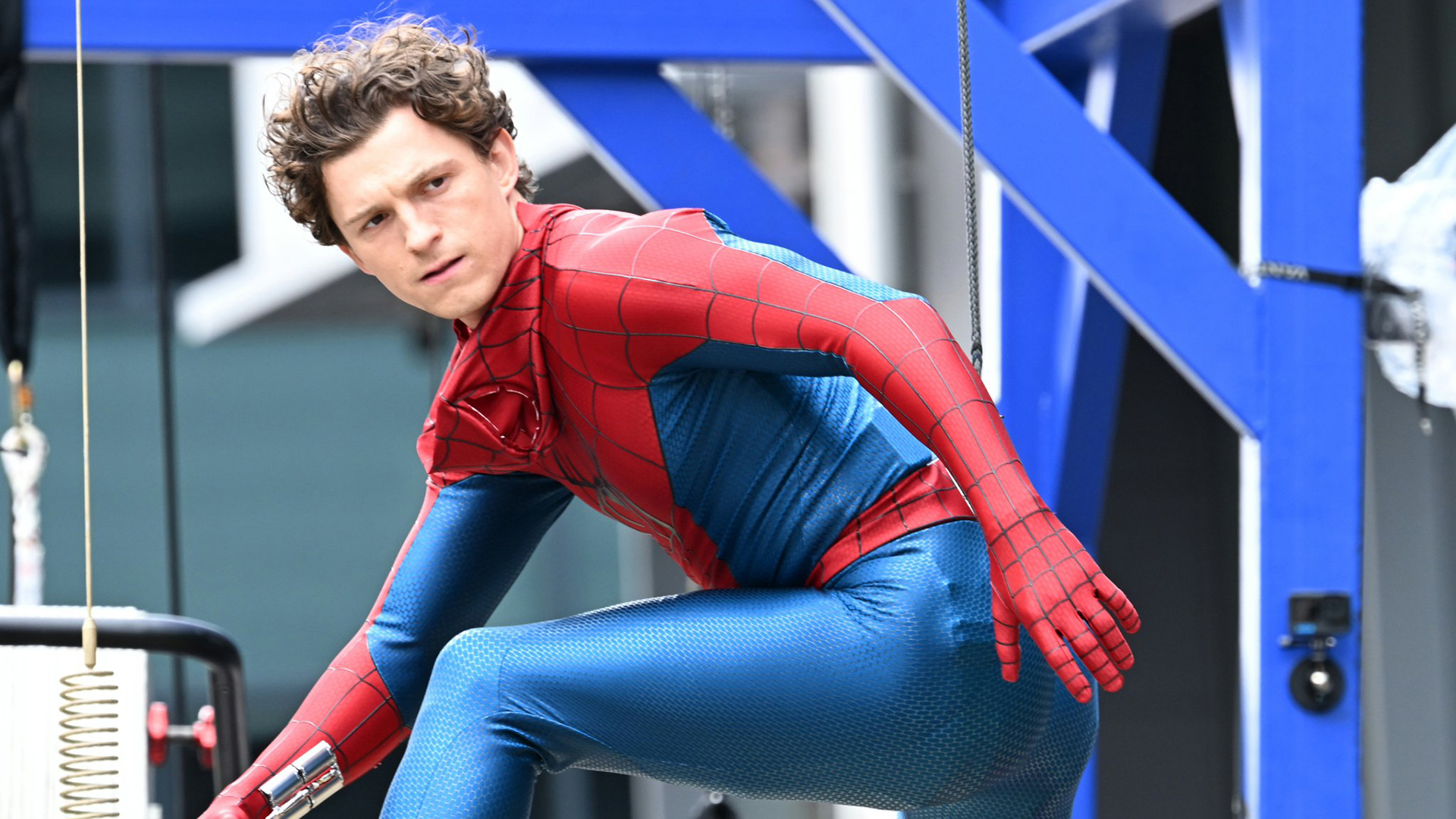 Tom Holland's unmasked superhero posing and looking over his left shoulder in Spider-Man: Brand New Day