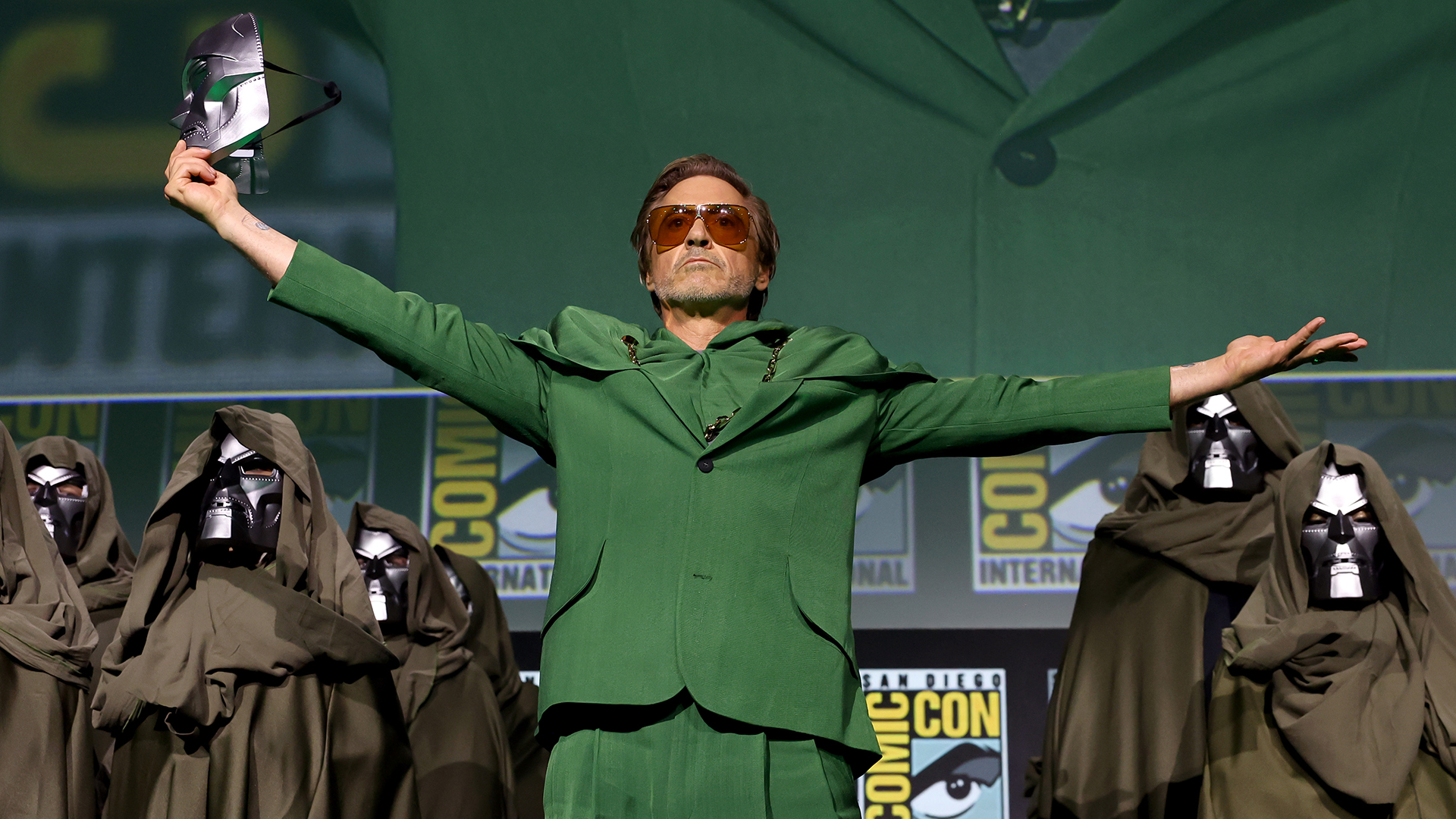 Robert Downey Jr wearing a green suit and sunglasses during Marvel's Hall H panel at San Diego Comic-Con 2024