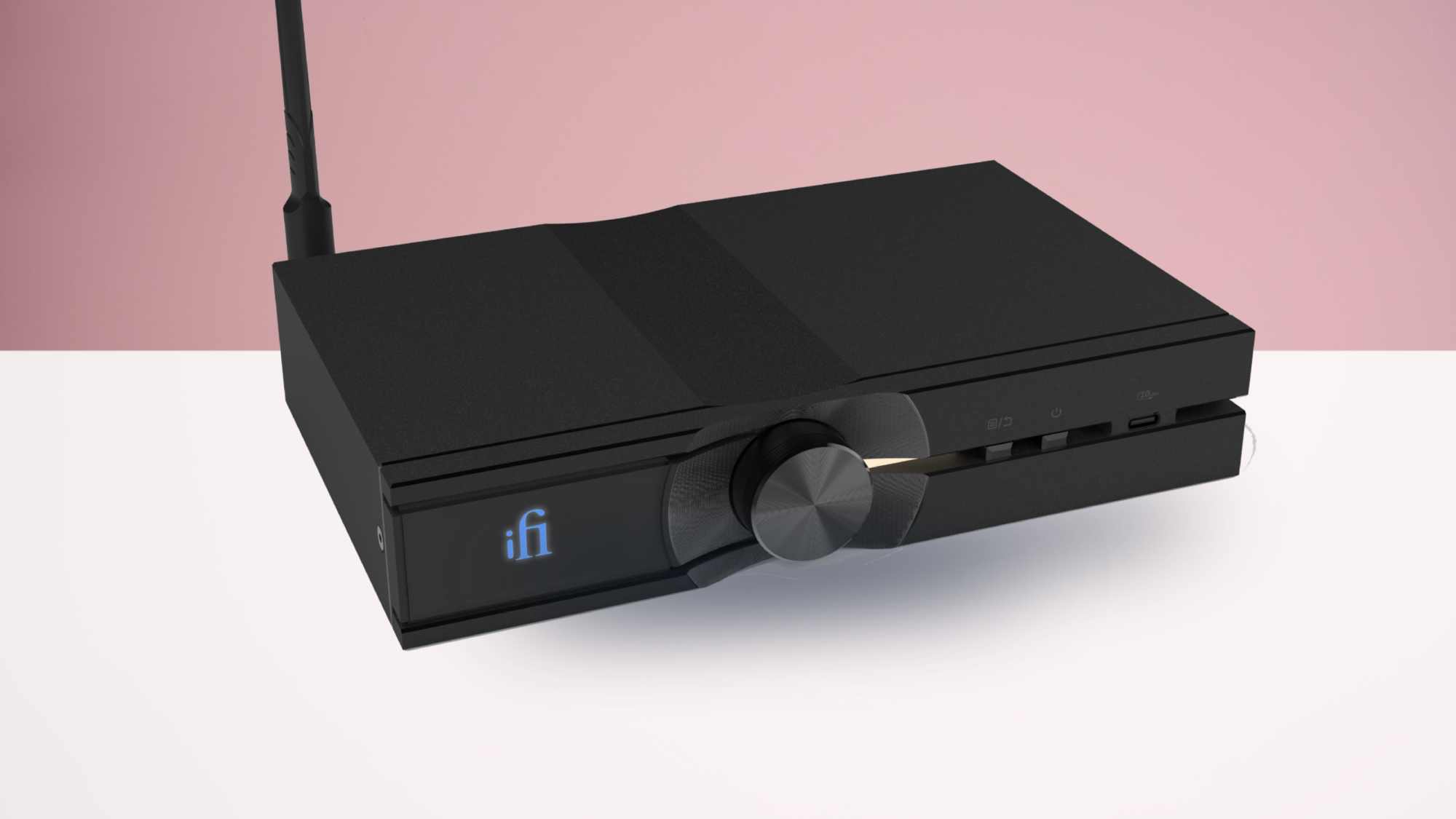 The iFi Neo Stream 3 on a white table with a pink background.