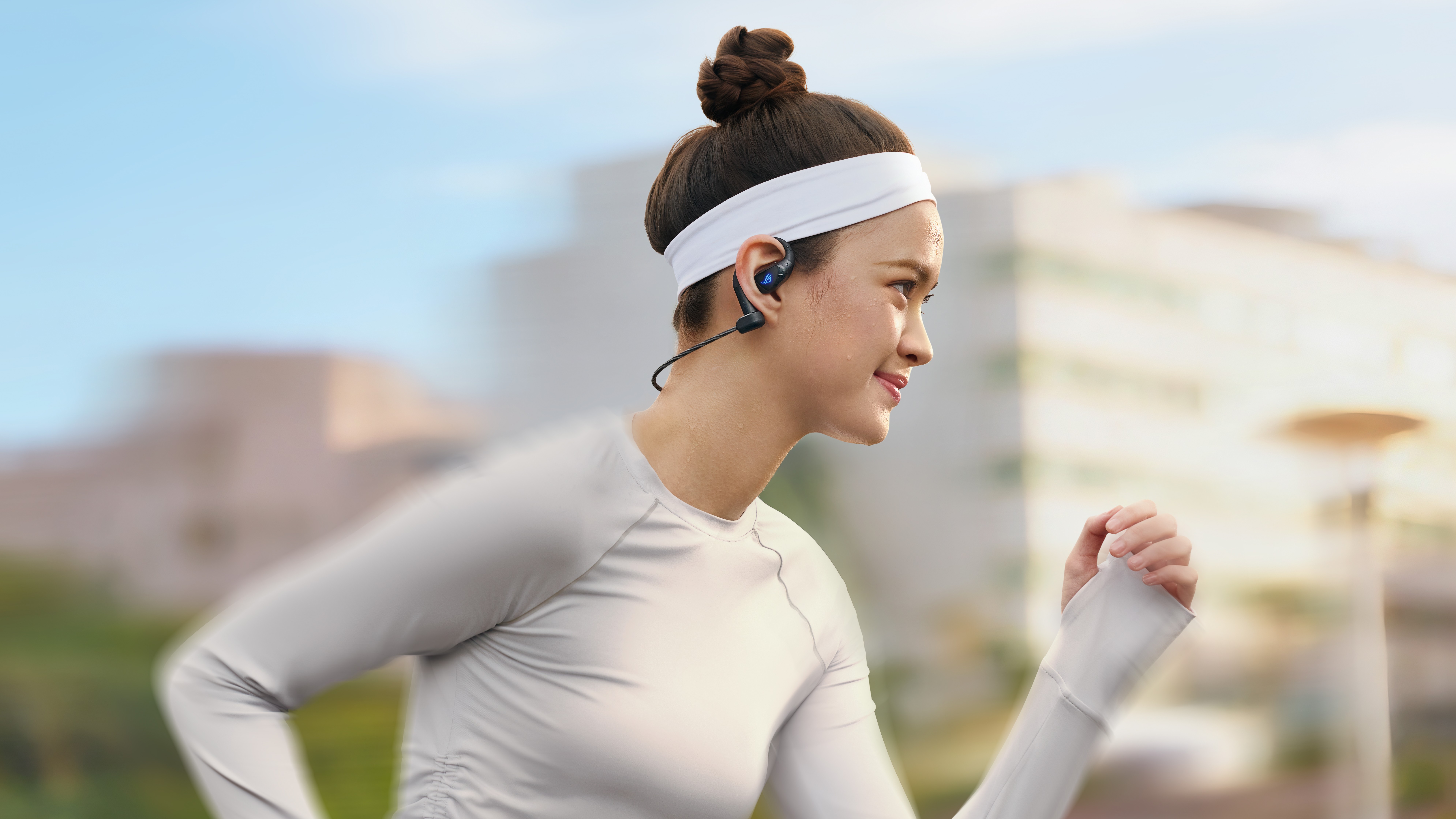A promotional image showing a woman wearing the Asus Rog Cetra Open Wireless open-ear earbuds.