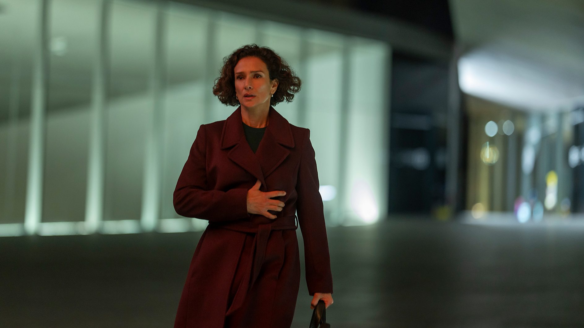 Indira Varma as Mayra Cavendish looking stressed walking by an office