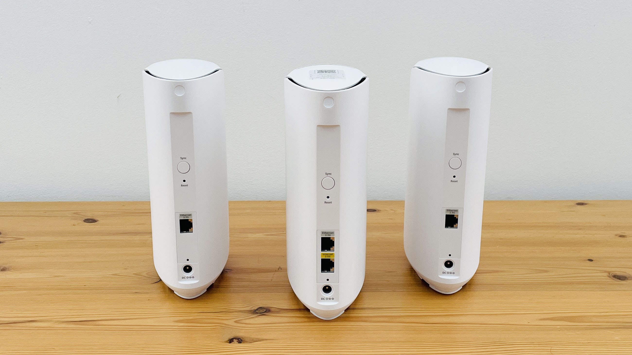 Netgear Orbi 373 with one router and two satellites on a wooden table