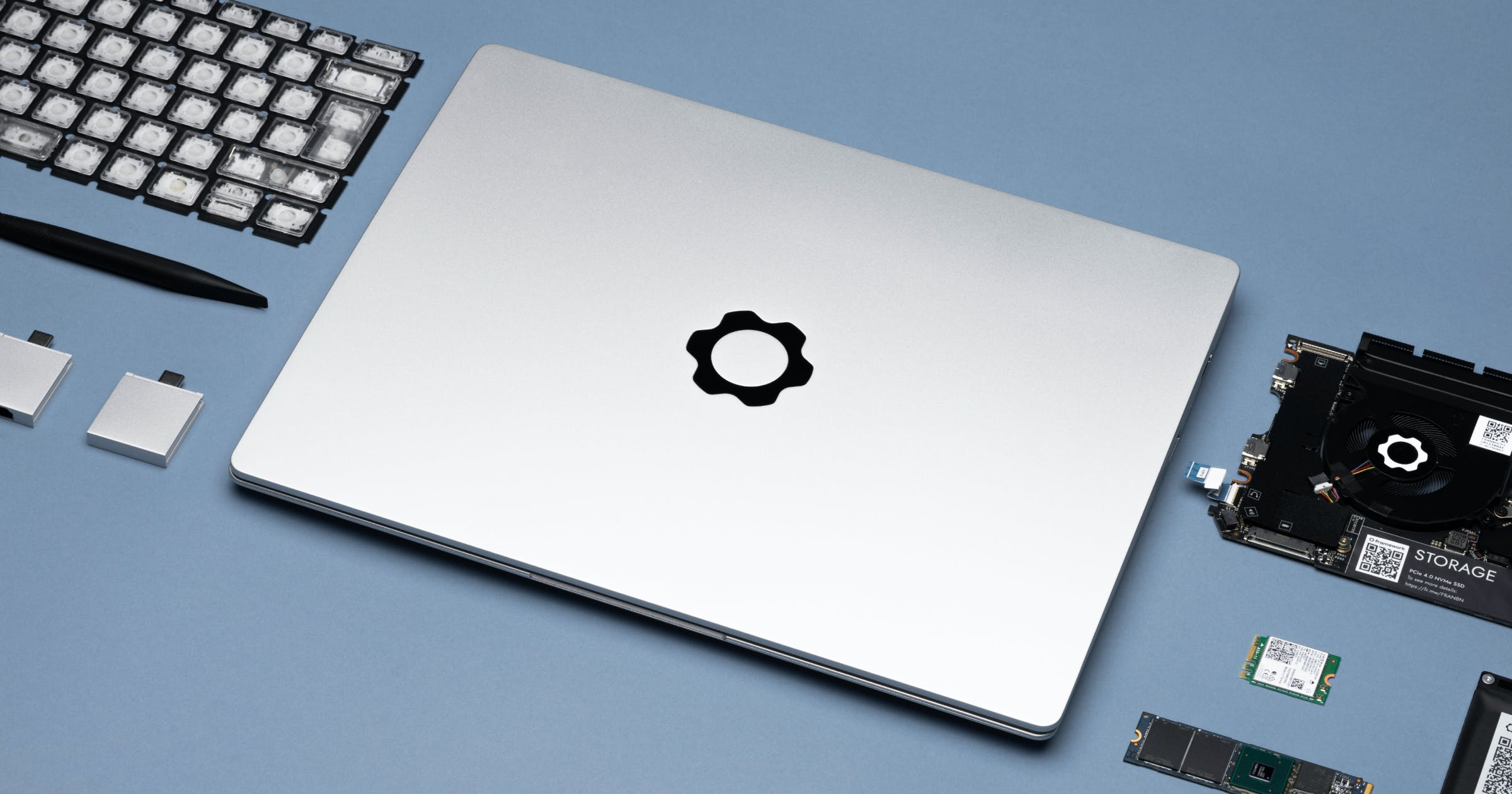 A lifestyle image of the Framework laptop surrounded by replaceable components