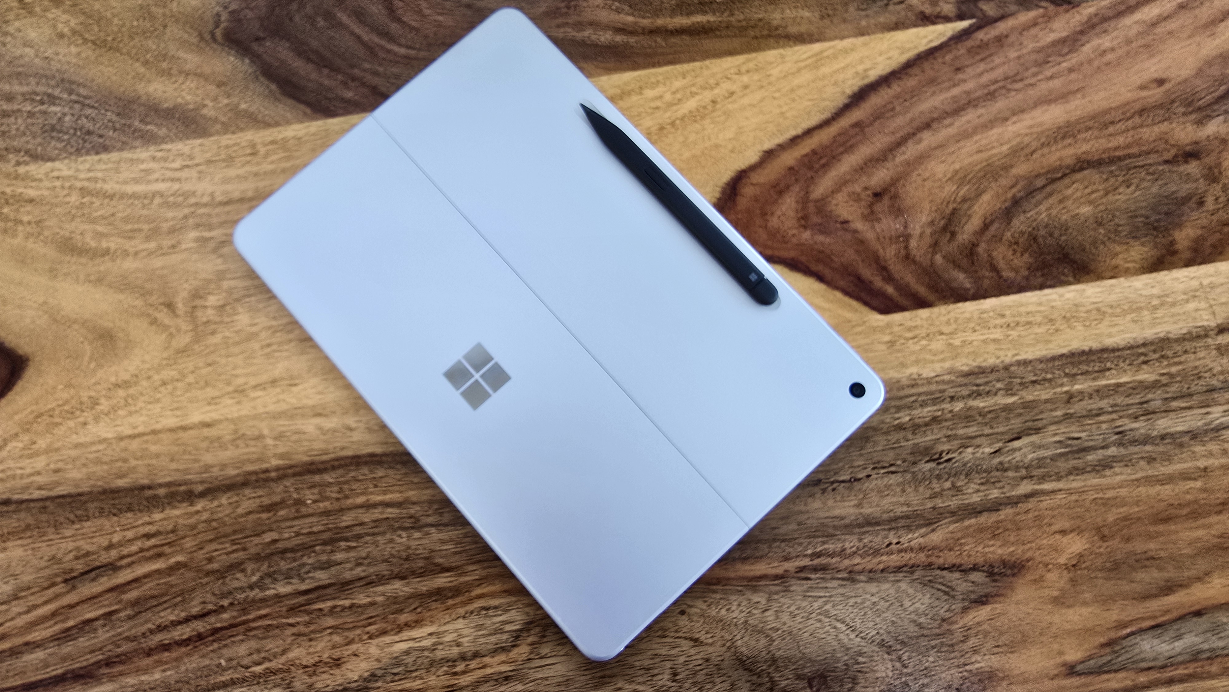 Microsoft Surface Pro 12 tablet on wooden table in relaxed cafe