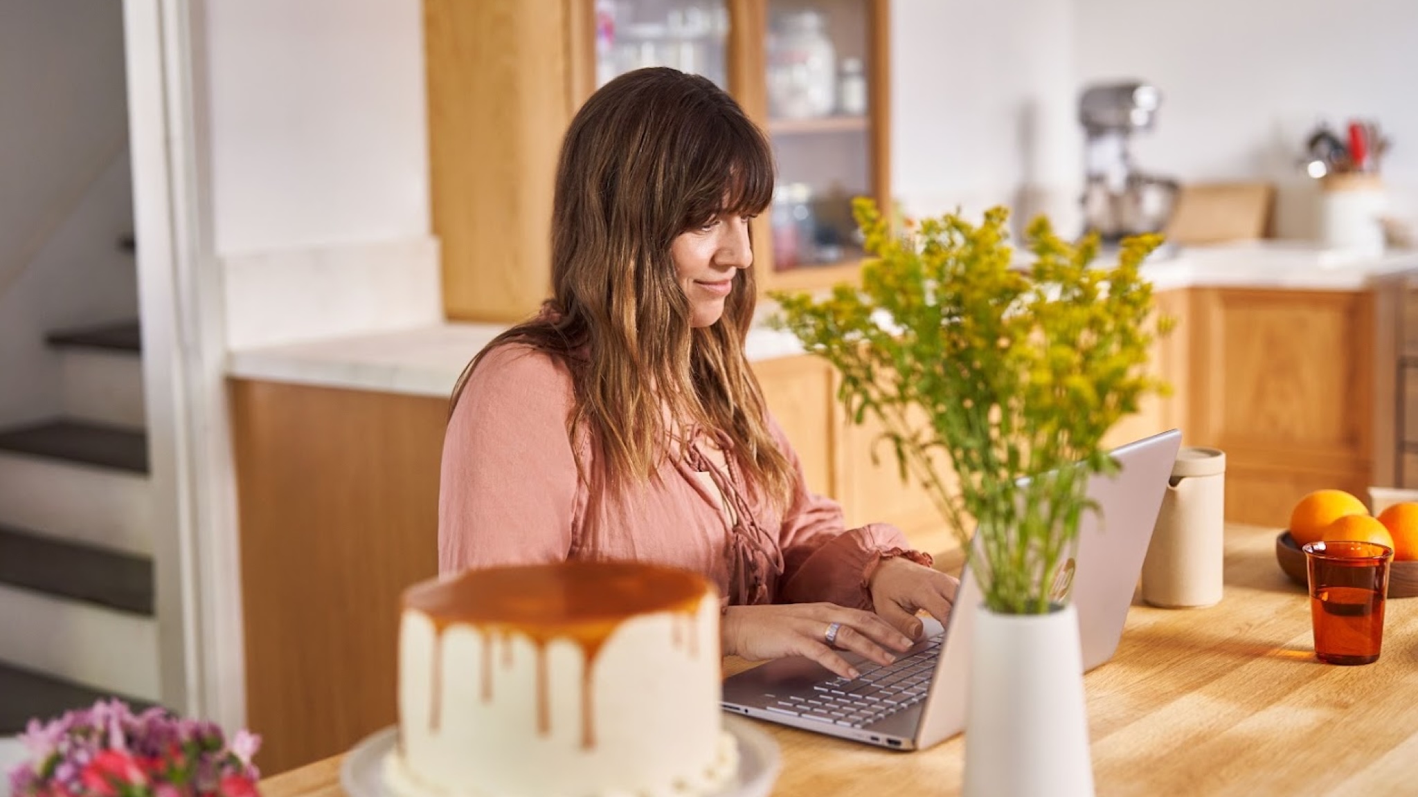 A person using a Windows 11 laptop at a desk while smiling