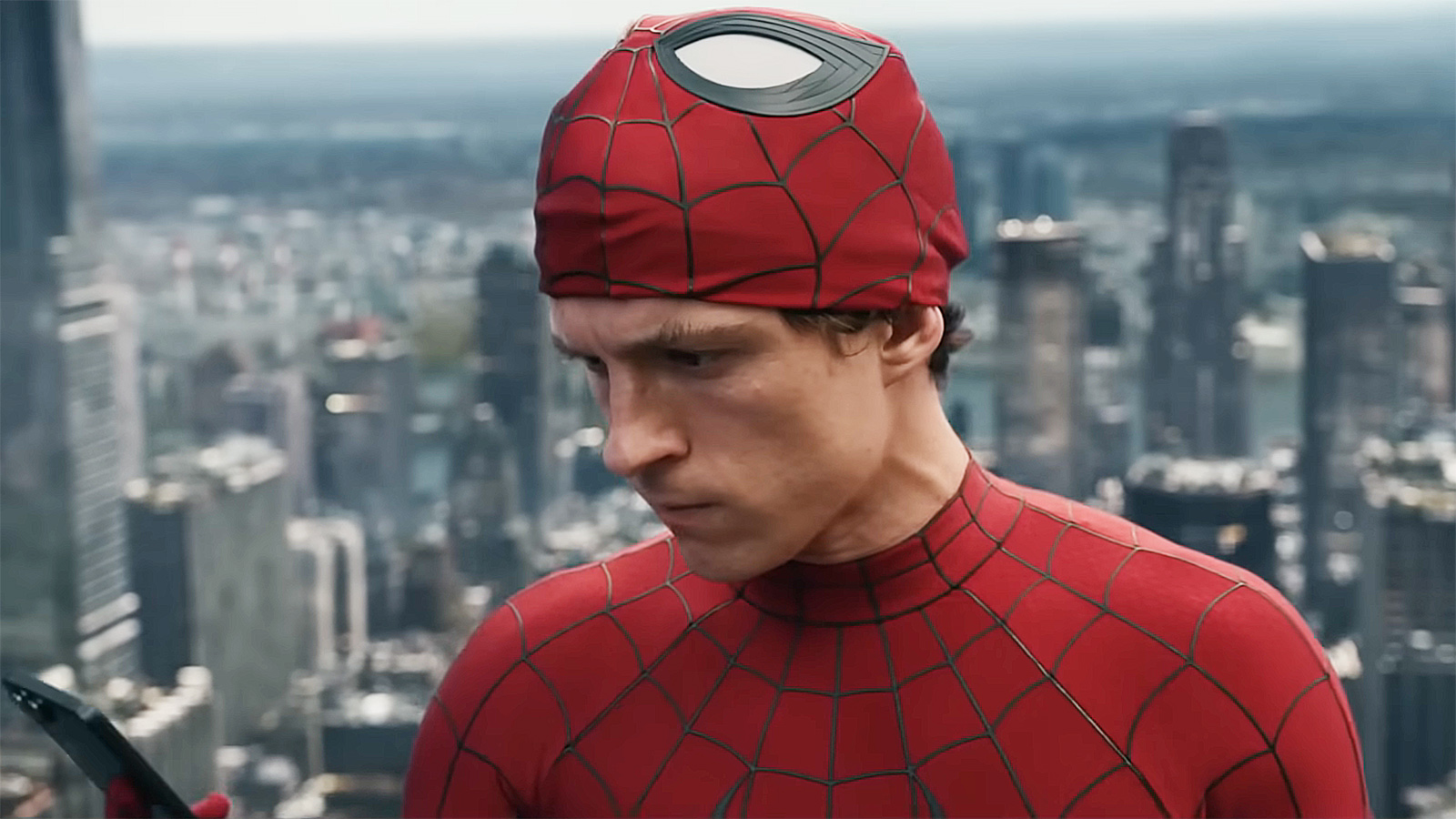 Peter Parker looking at his mobile phone with his Spider-Man mask on his head in Spider-Man: Brand New Day