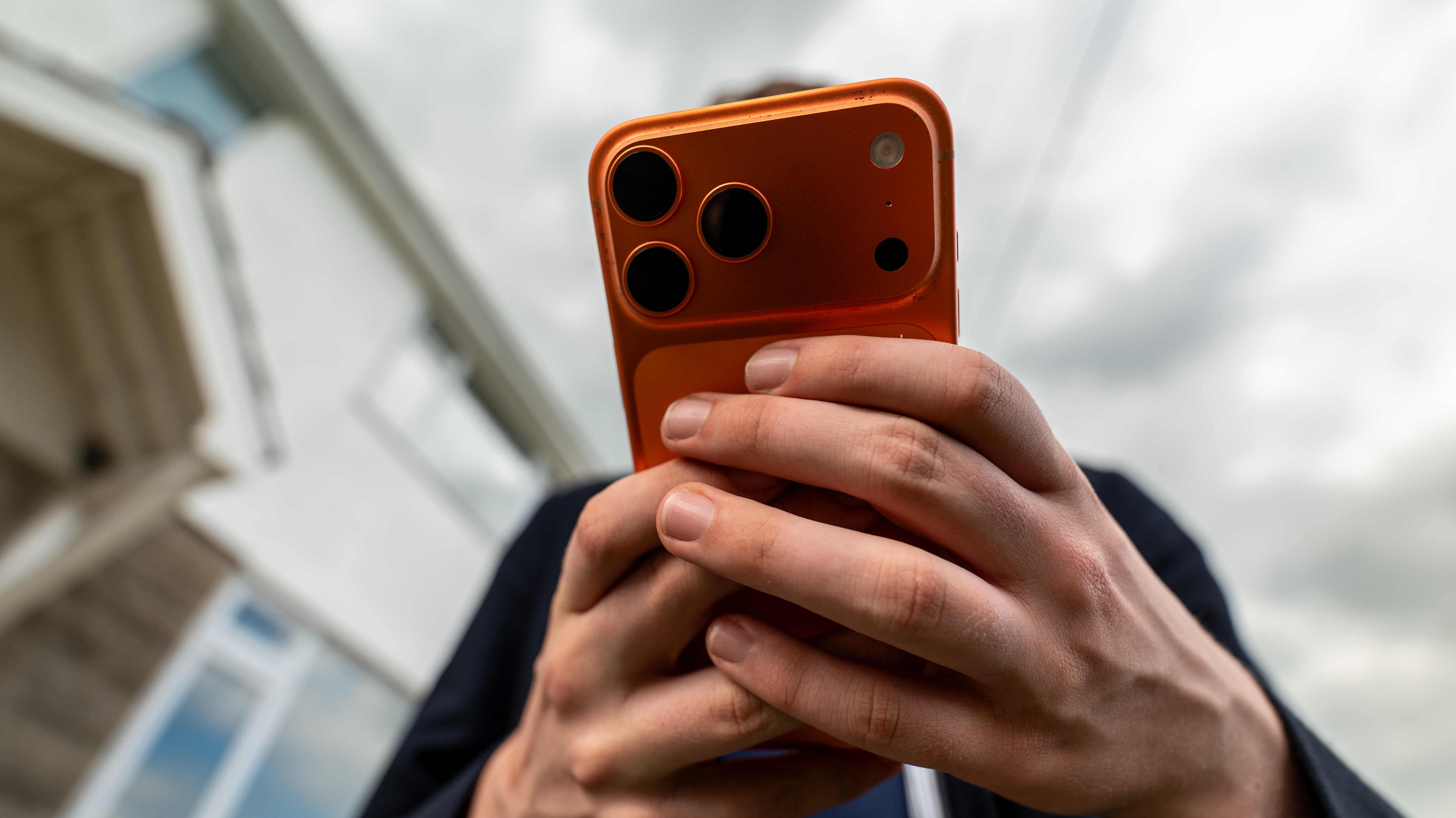 A child holding an orange iPhone