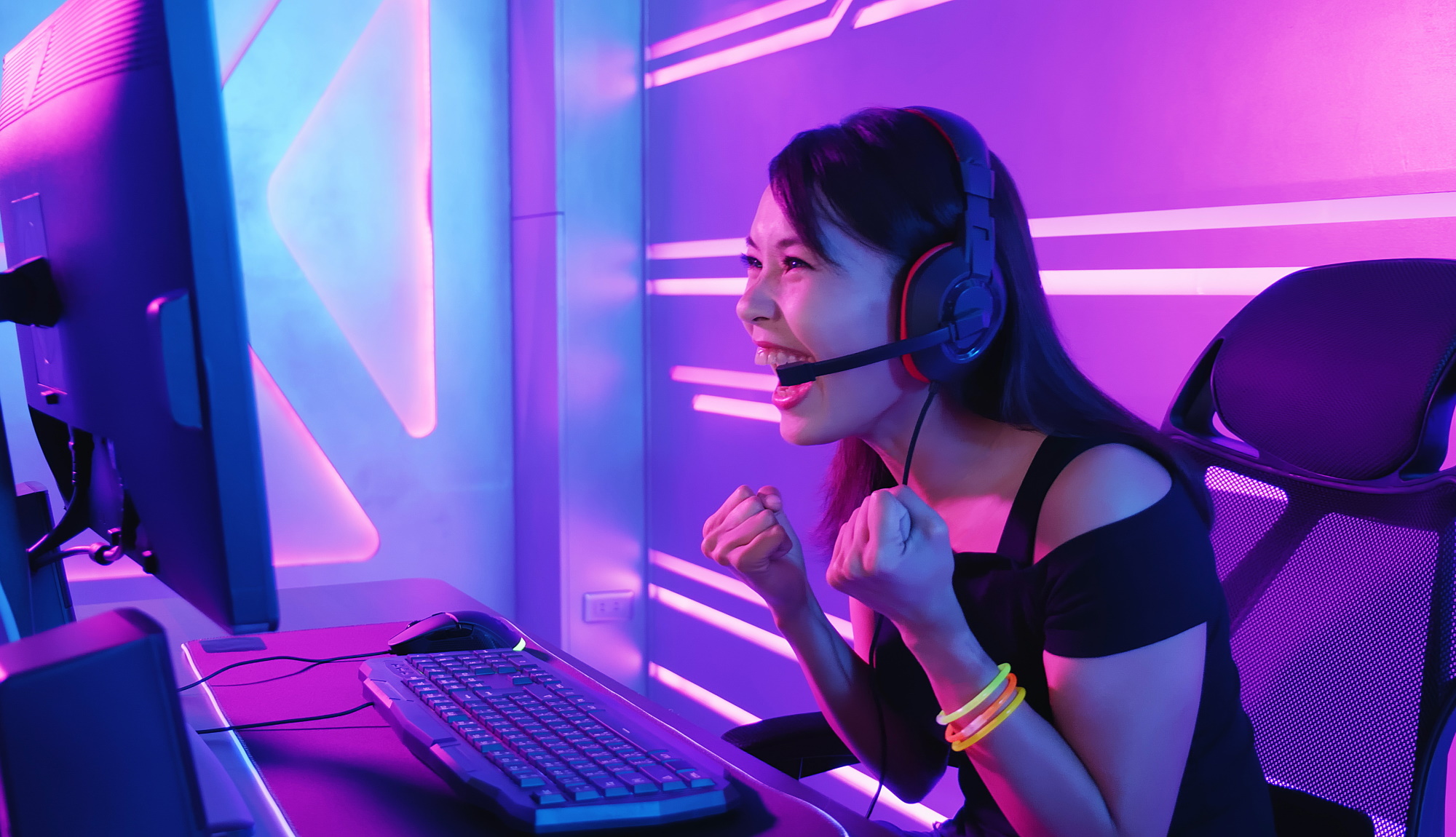 Person at a PC looking happy, wearning headphones