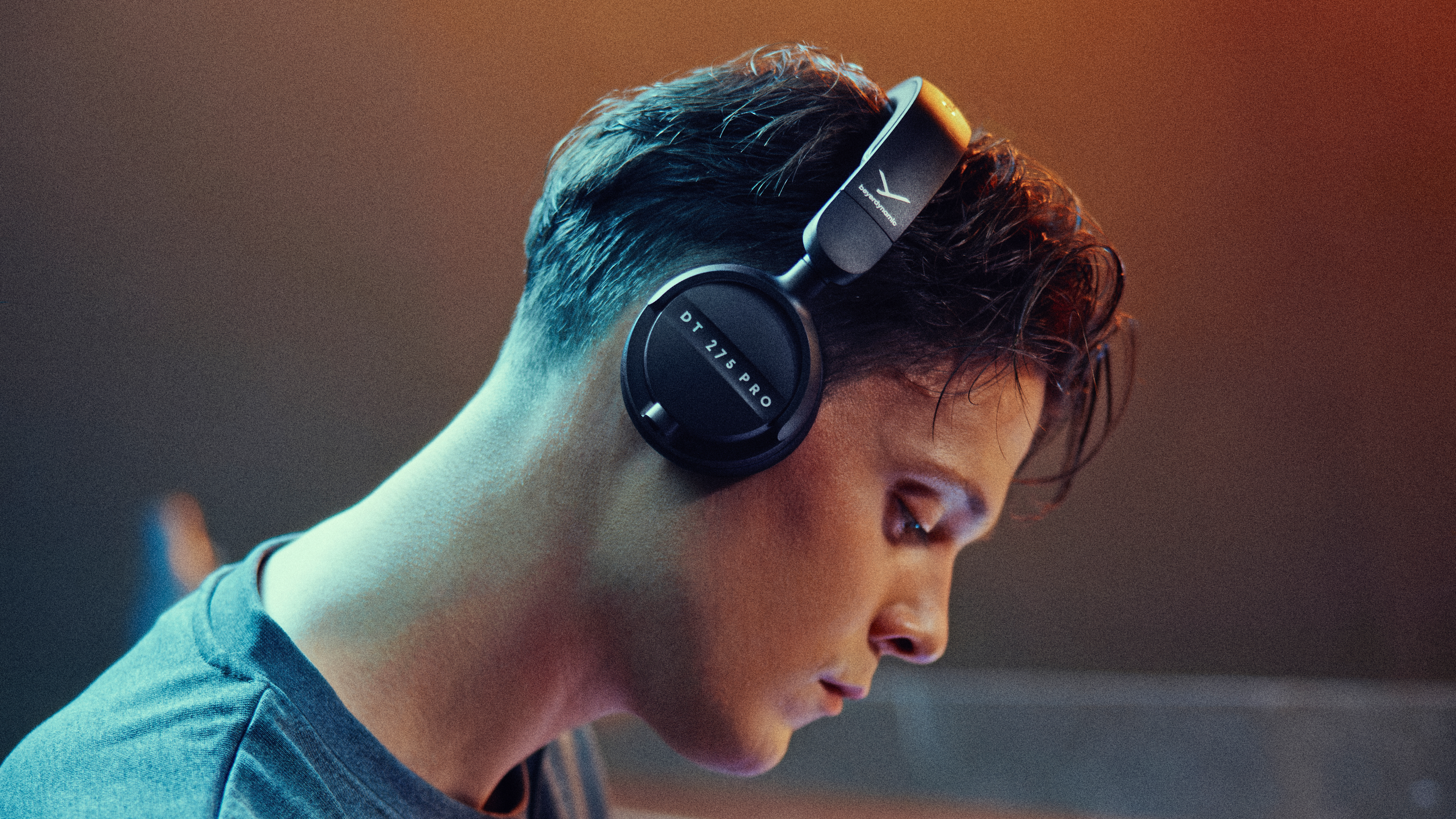 A man wearing Beyerdynamic DT 275 Pro headphones while playing in a live music venue