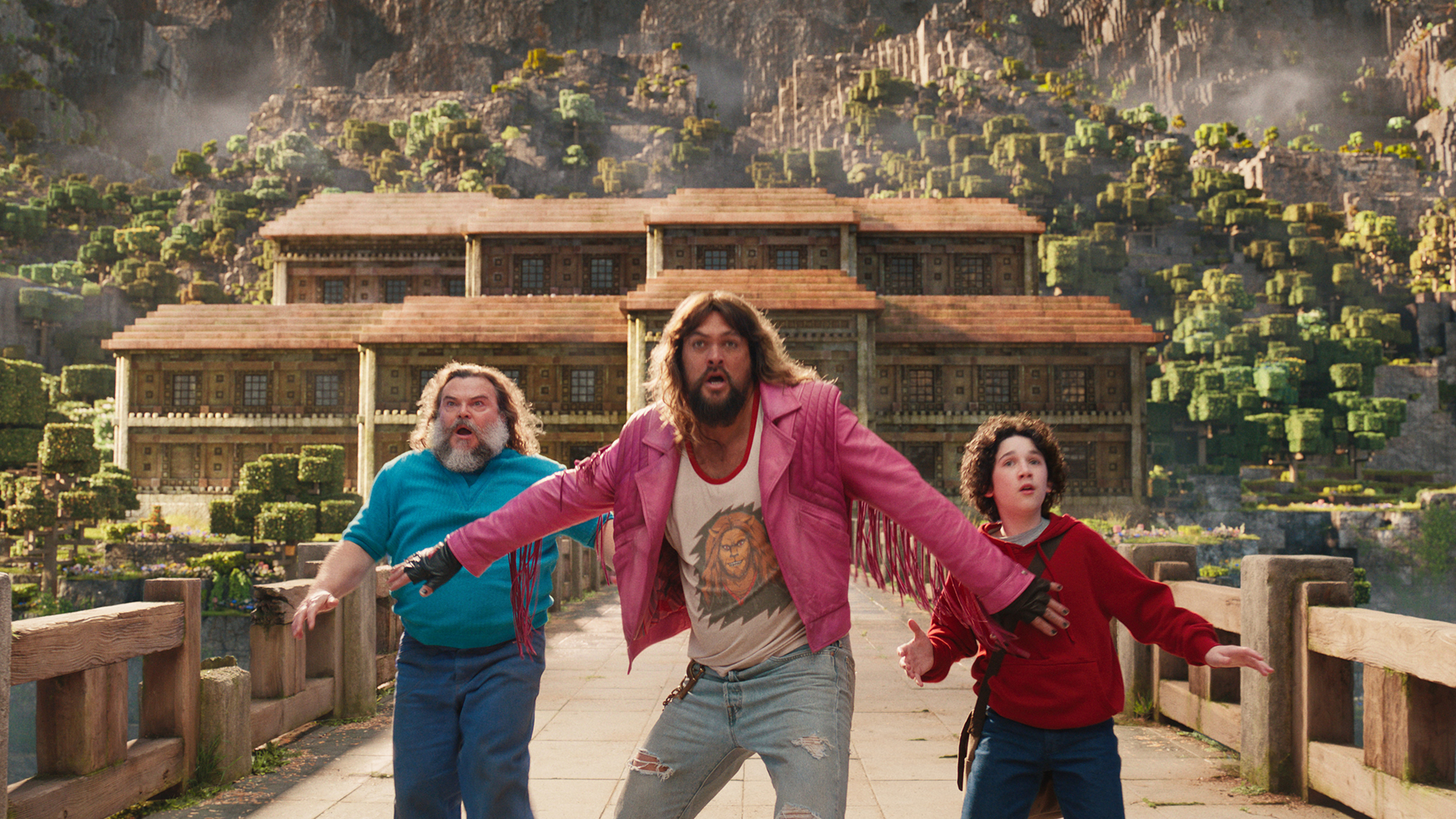 Garrett holding Steve and Henry back on a bridge in A Minecraft Movie