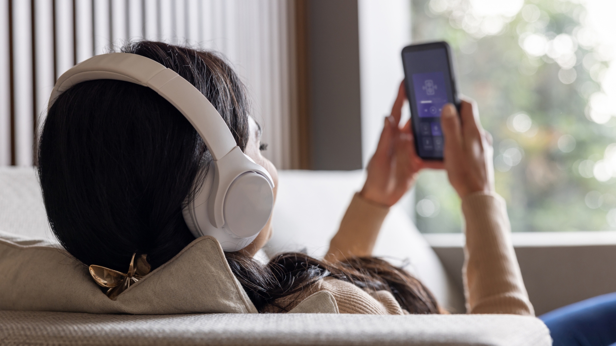 Woman listening to music via smartphone streaming